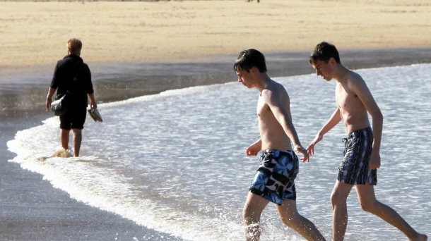 Unos jóvenes se bañan en la playa de La Concha, en Donostia-Sebastián.