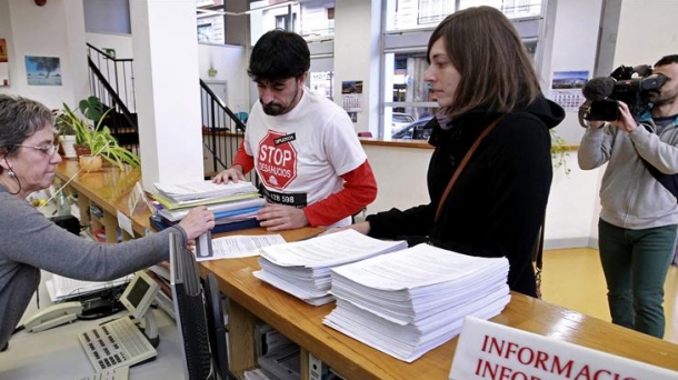 Los representantes de Stop Desahucios entregan las firmas. 