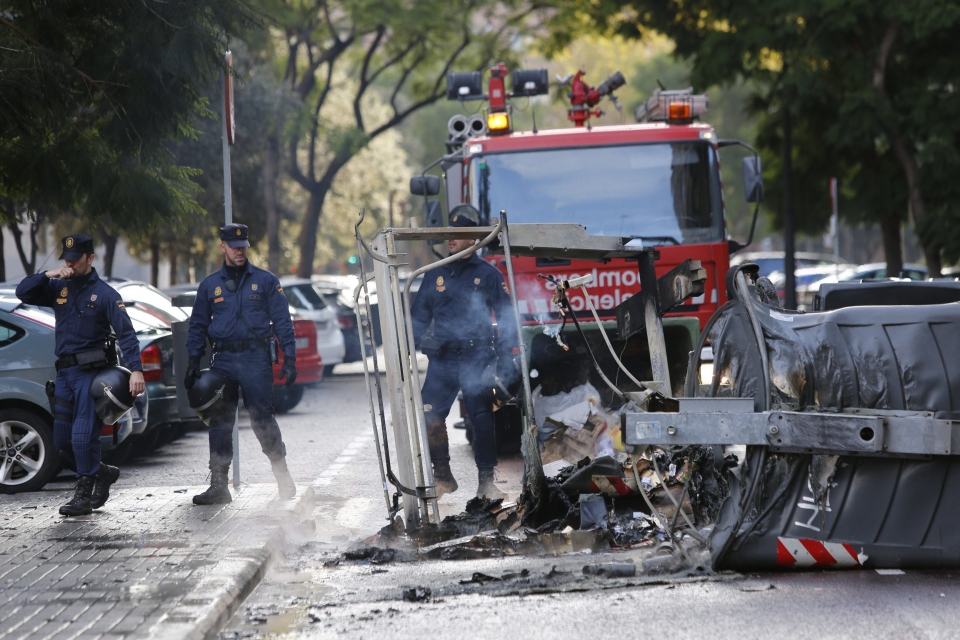 La Policía observa un contenedor quemado en Valencia. Foto: EFE