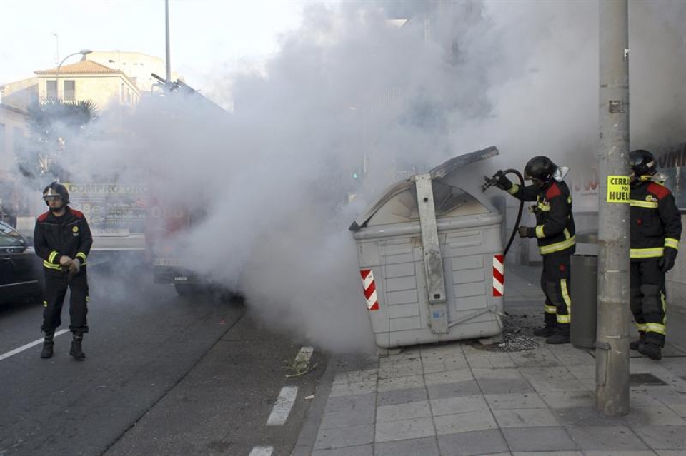 Los bomberos intentan apagar unos contenedores a los que han prendido fuego, en Salamanca. Foto: EFE