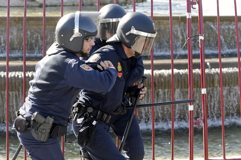 Dos Policías ayudan a un compañero herido en los altercados en la manifestación de Madrid. Foto: EFE
