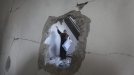 Emakume palestinar bat suntsitutako etxe batean. Argazkia: EFE title=