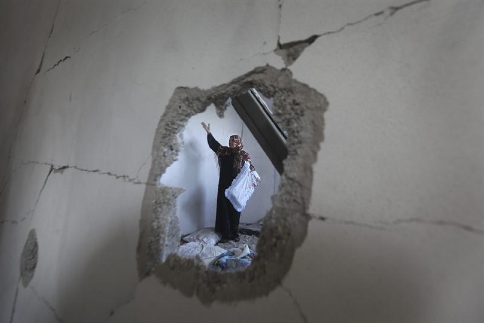 Emakume palestinar bat suntsitutako etxe batean. Argazkia: EFE