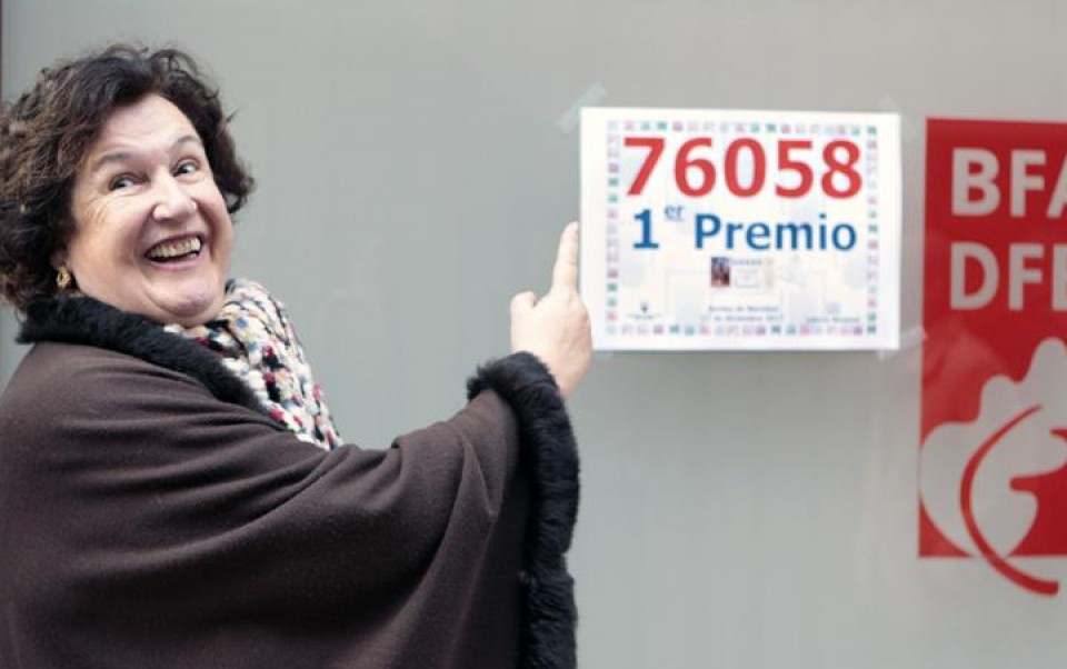 Maite Madariaga, delegada en Bizkaia de LAE, señala el número del gordo que ha vendido en Bilbao. 