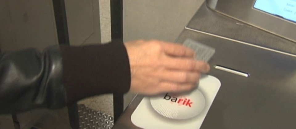 Una persona entrando al metro con una tarjeta Barik.