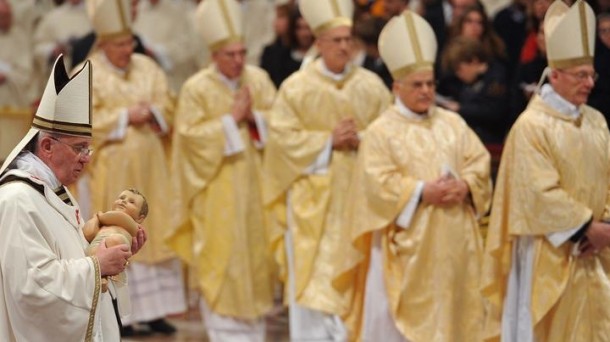 El papa Francisco sostiene una estatua del niño Jesús. 