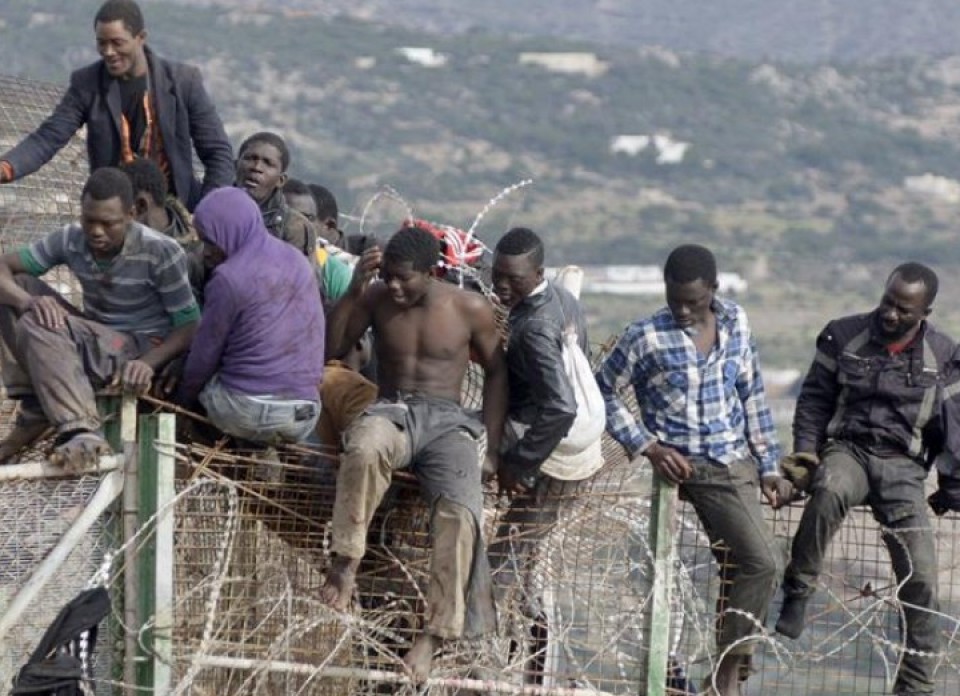 Cerca de 20 inmigrantes permanecen subidos a la valla fronteriza de Melilla EFE.