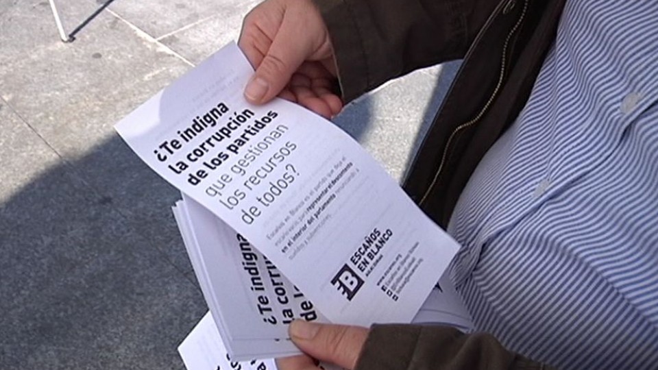 Un hombre lee propaganda de Escaños en Blanco en Bilbao. EiTB