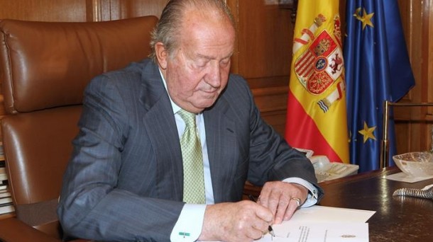 El rey, en el momento de firmar su abdicación. Efe.