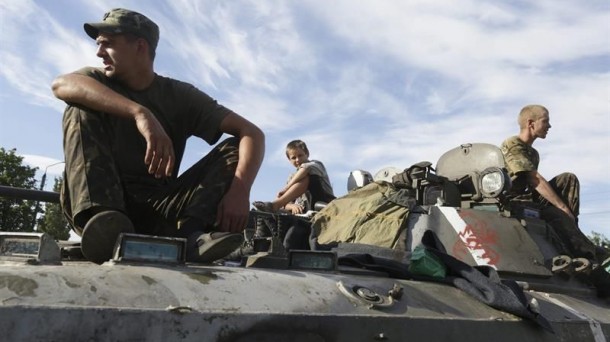 Varios soldados ucranianos y un niño descansan sobre un tanque en Donetsk. Foto: EFE