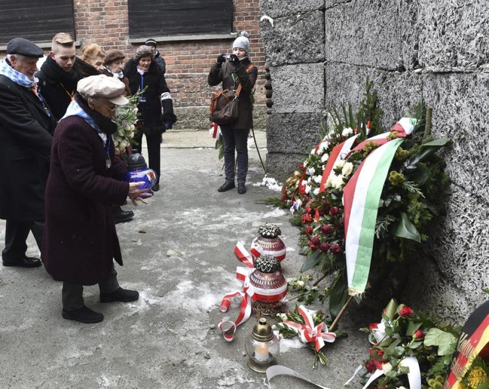 Supervivientes del campo de concentración depositan flores en el Muro de la Muerte. EFE