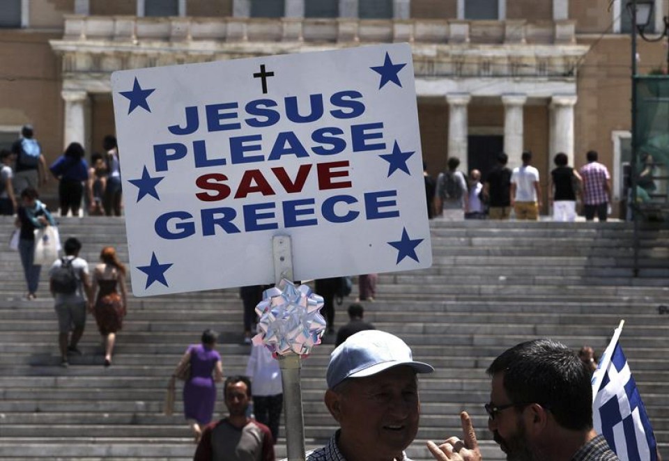 Un hombre sostiene una pancarta en la plaza Sintagma de Atenas. Foto: EFE