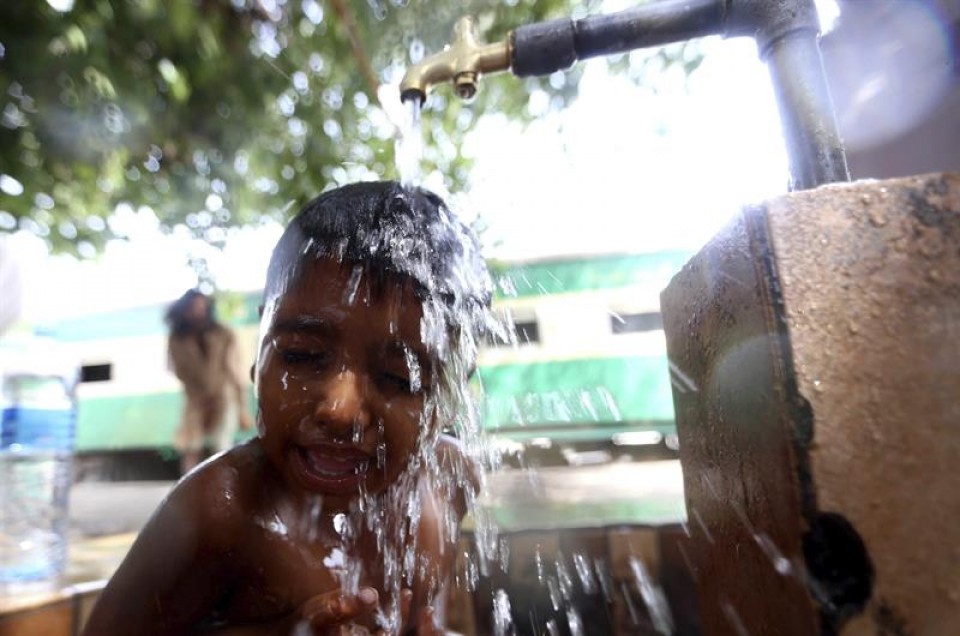 Un niño se refresca un caluroso día en Karachi. Foto: EFE