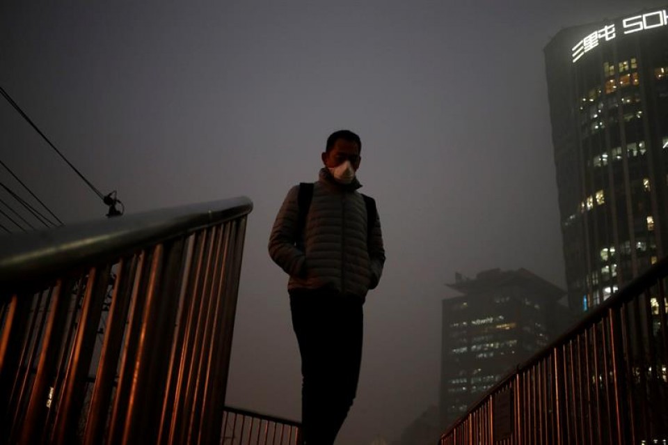 Un hombre que pasea con máscara por las calles contaminadas de Pekín (China). Foto: EFE