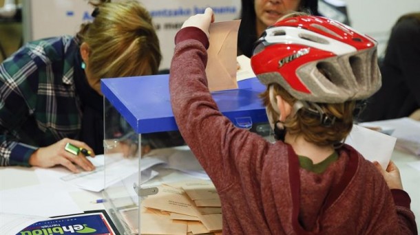 Un niño introduce la papeleta de sus padres en una urna de un colegio electoral de Donostia. EFE. 