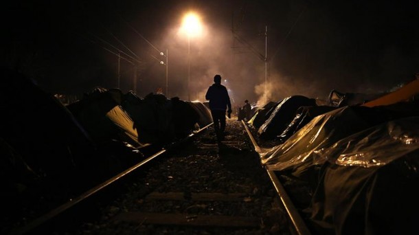 Un refugiado camina en las vías del tren en el campamento de Idomeni (Grecia). Foto: EFE