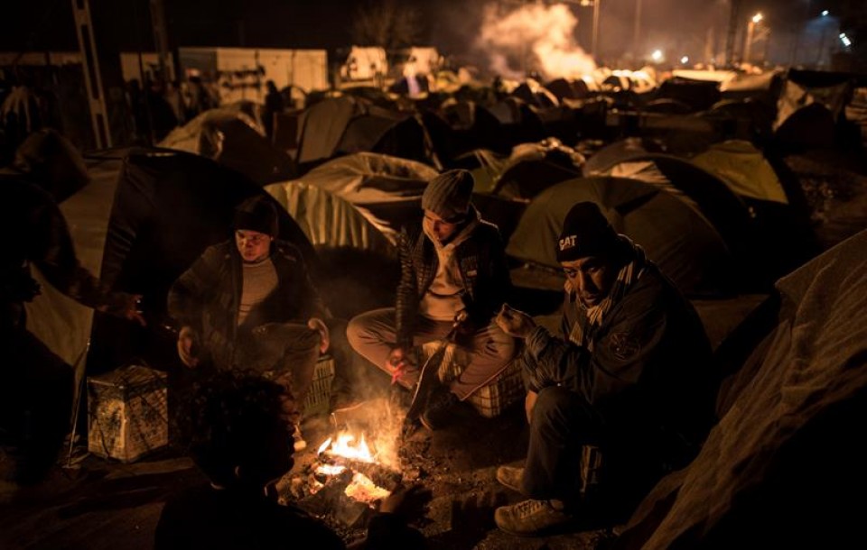 Migrantes y refugiados descansan un campamento en Idomeni (Grecia) en la frontera con Macedonia. EFE