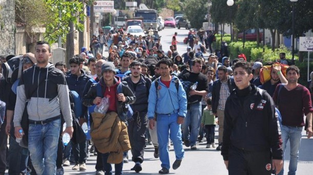 Un grupo de refugiados camina por una calle de Grecia. Foto: EFE.