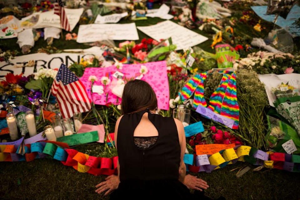 Una mujer deja flores en un monumento improvisado para las víctimas del tiroteo en Orlando. EFE