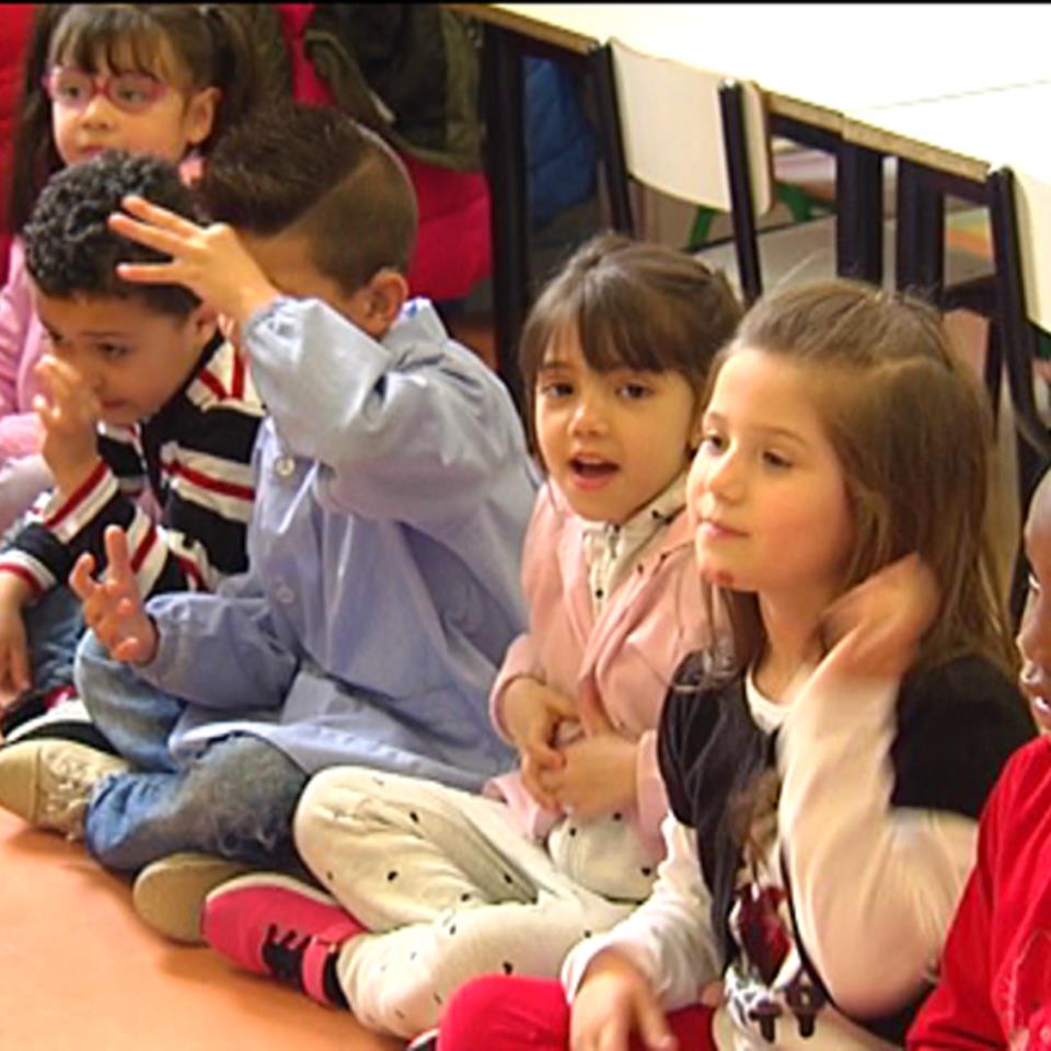 Niños practicando la lengua de signos en un aula