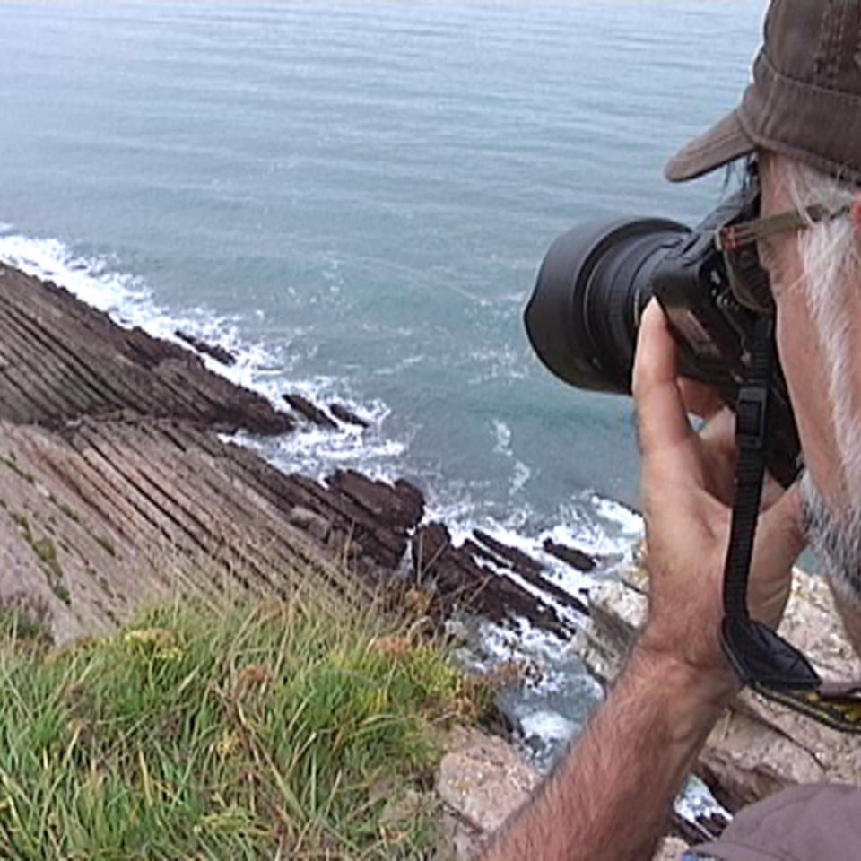 Un hombre fotografía un rincón de la costa vasca. Foto obtenida de un vídeo de EiTB. 