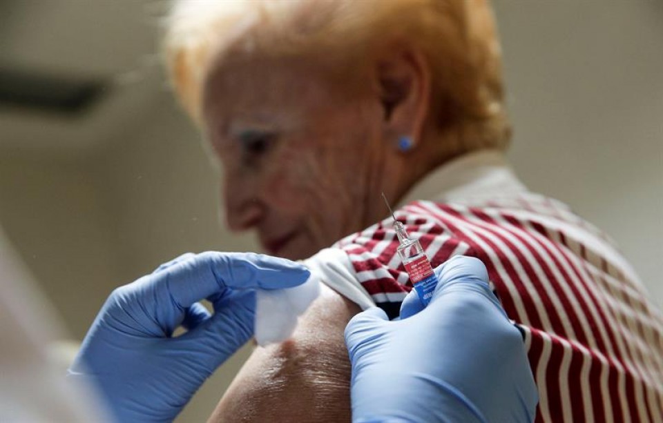 Una mujer mayor siendo vacunada por la gripe