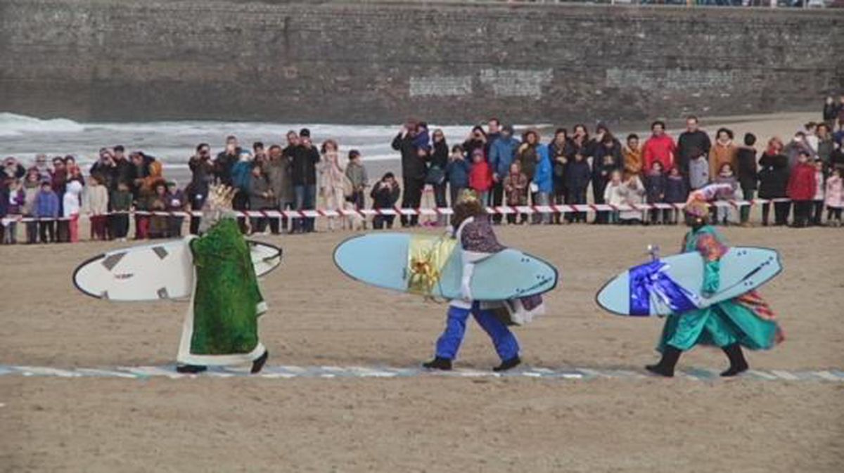Los Reyes Magos pasean por una de las playas de San Sebastián cada uno con una tabla de surf.