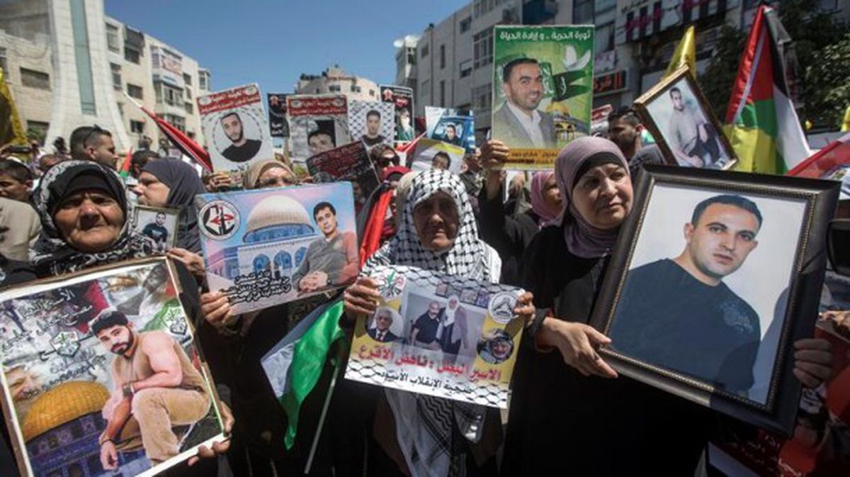 Mujeres palestinas con carteles con imágenes de sus parientes encarcelados en Israel. EFE. 