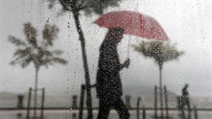 Una mujer camina bajo la lluvia en San Sebastián. 