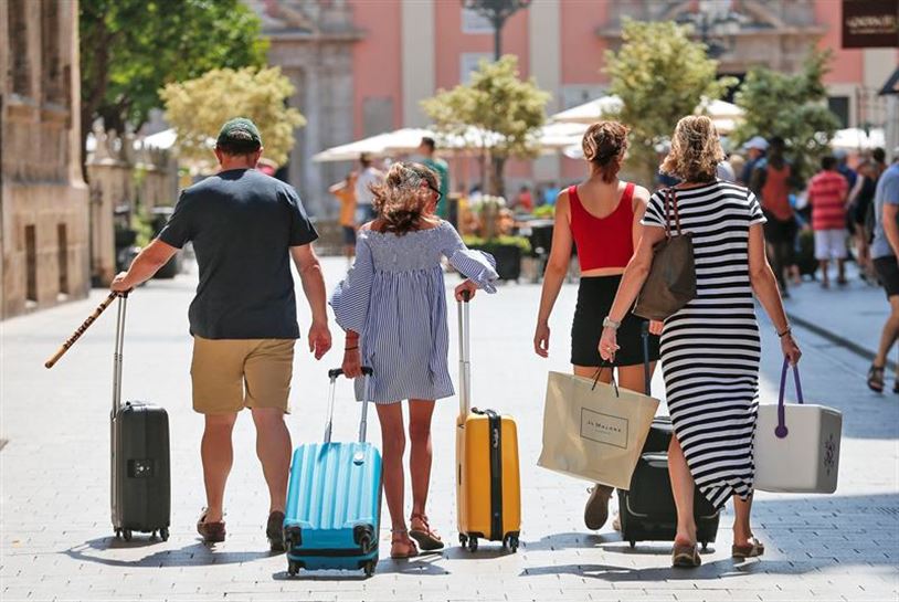 Una familia, con las maletas en mano, de viaje.