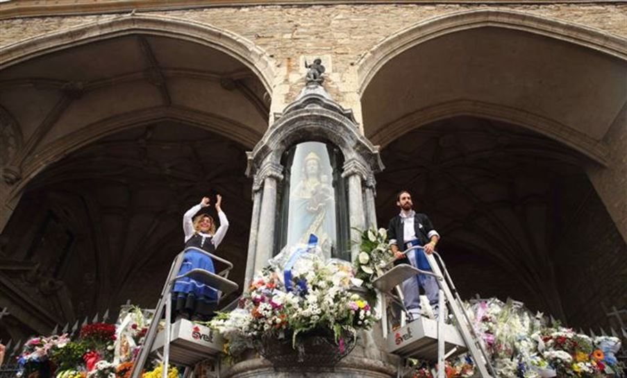 Nesken eta blusen koadrilek lore eskaintza egin diote Andre Maria Zuriari. Argazkia: EFE