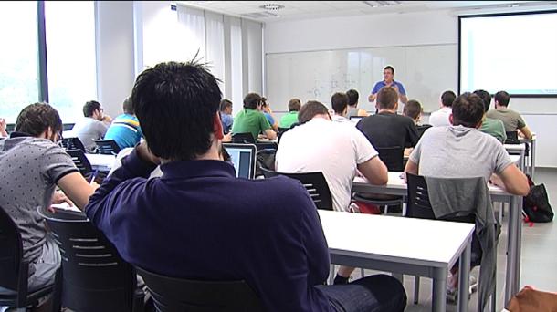 Estudiantes atienden al profesor en una clase.