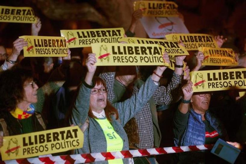 Varias personas protestan durante la concentración frente al Parlamento catalán. Foto: EFE
