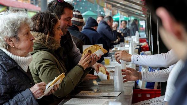 Varios ciudadanos degustan talos. Foto: EFE