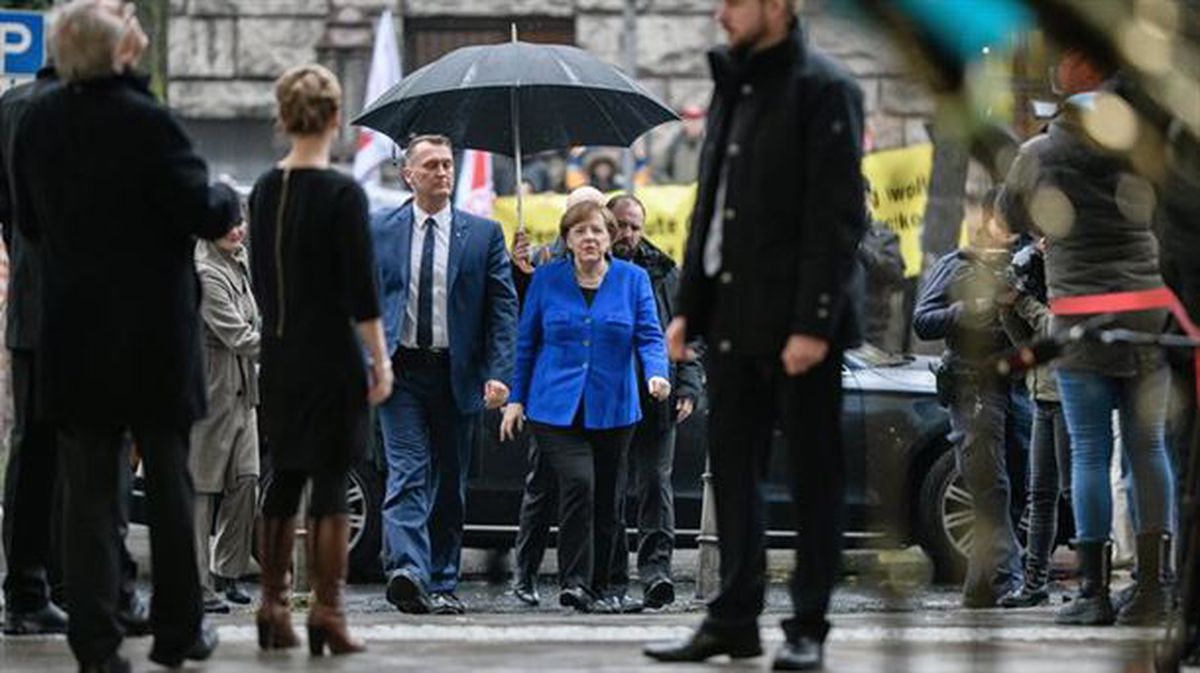 Ángela Merkel llega a la sede socialdemócrata en Berlín bajo la lluvia.