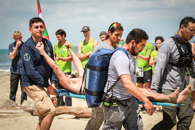 Operarios médicos trasladan a uno de los concursantes en una camilla