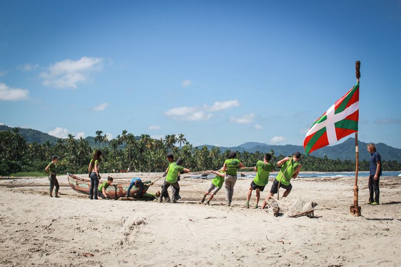 Los concursantes del equipo verde arrastrando su canoa