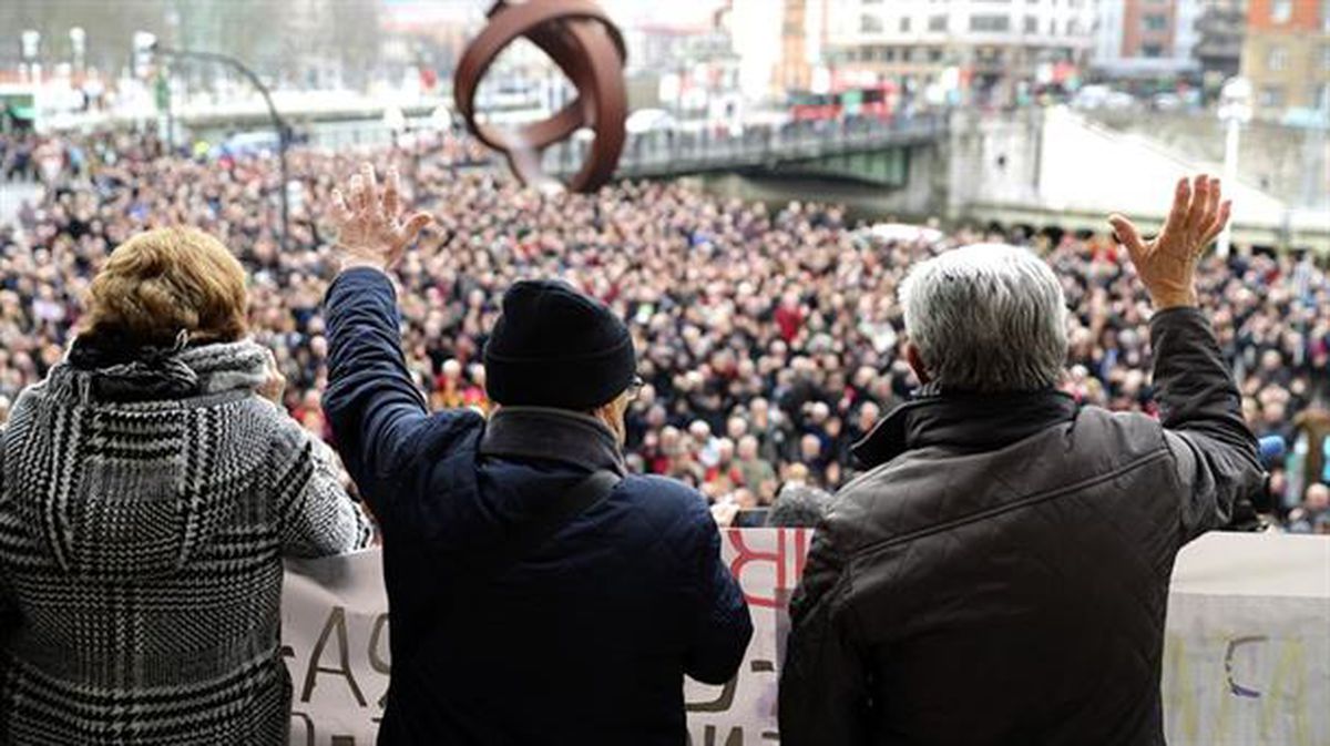 Pensionistas protestan con carteles y portan una ristra de chorizos, frente al Consistorio bilbaino.