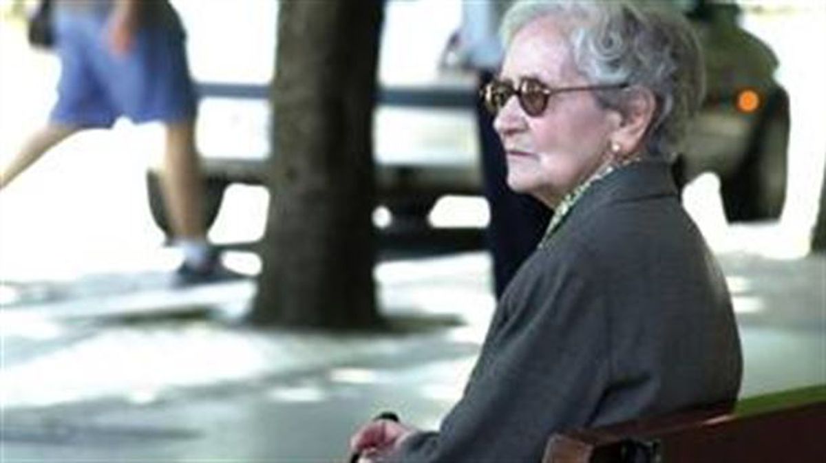 Una mujer sentada en un parque. Foto extráida de un vídeo de ETB.