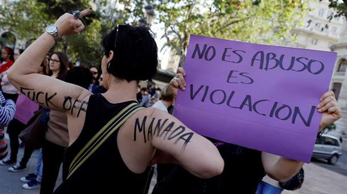 Una mujer sostiene un cartel en el que se lee "no es abuso es violación"