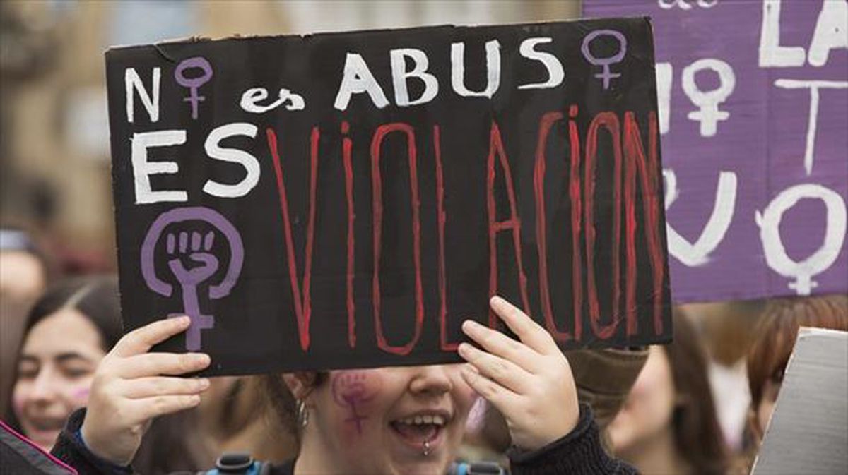 Una mujer muestra un cartel con el lema "no es abuso, es violación" durante una protesta.