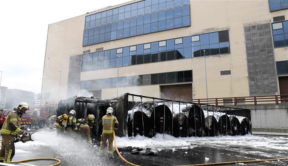 Bomberos trabajando en el camión incendiado. Foto: EFE