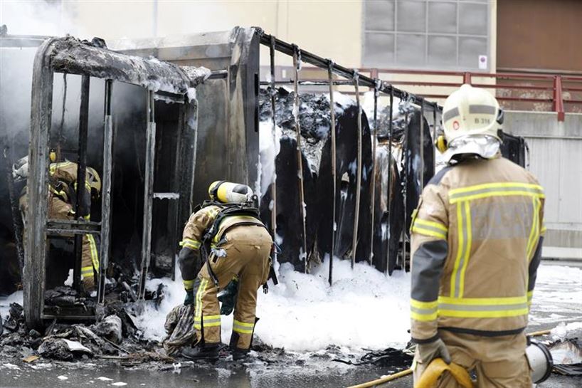 Bomberos trabajando en el camión incendiado. Foto: EFE