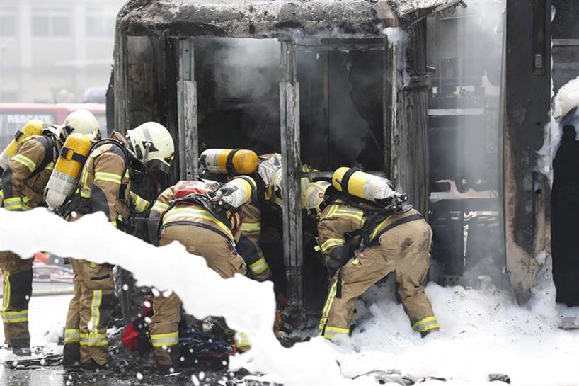 Bomberos trabajando en el camión incendiado. Foto: EFE