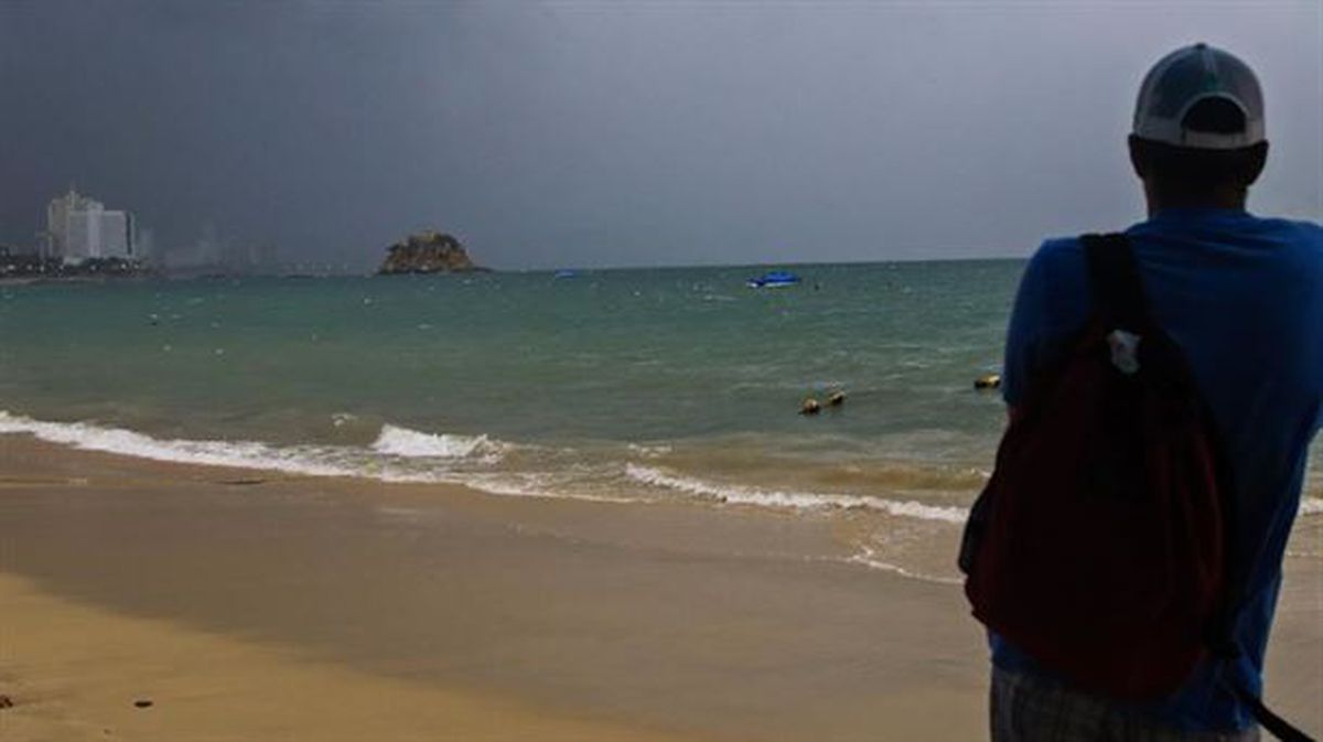 Un turista observa el mar en una playa en las costas de Acapulco.