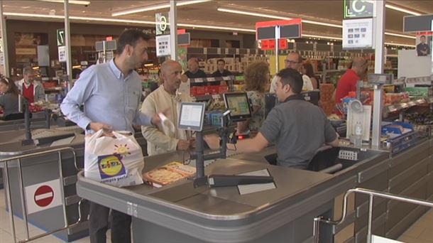 Cajero de un supermercado atendiendo a los clientes