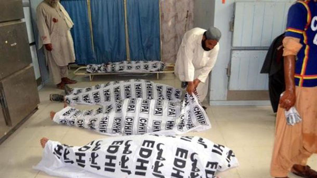 Un hombre cubre los cuerpos de las víctimas del atentado contra el ANP, en Quetta (Pakistán). EFE