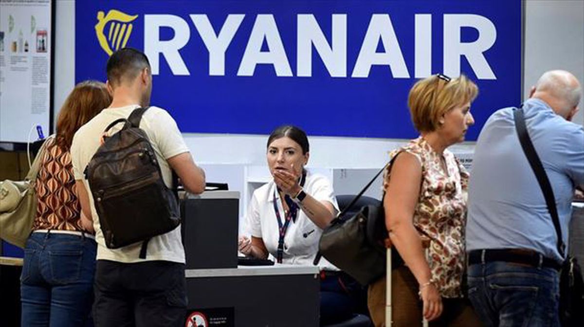 Ryanair konpainiako langile bat bezeroekin. Artxiboko argazkia: EFE