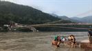 Los locales se bañan bajo el Puente Colgante de Ram Jhula en Rishikesh.