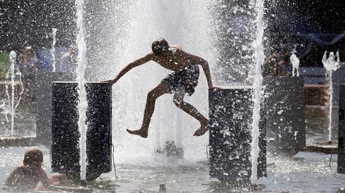 Un niño se refresca en una fuente por las altas temperaturas. Foto de archivo EFE